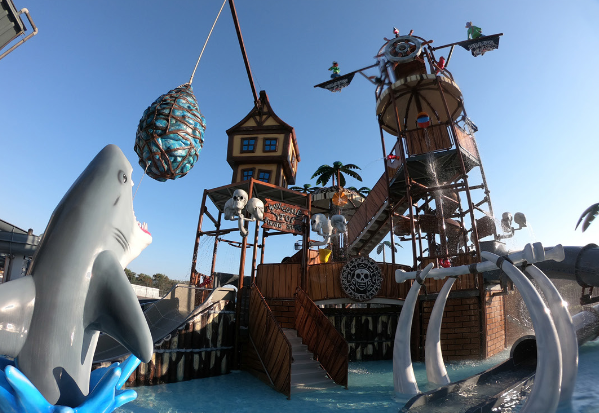 Outdoor splash pad with themed water cannons and climbable play towers